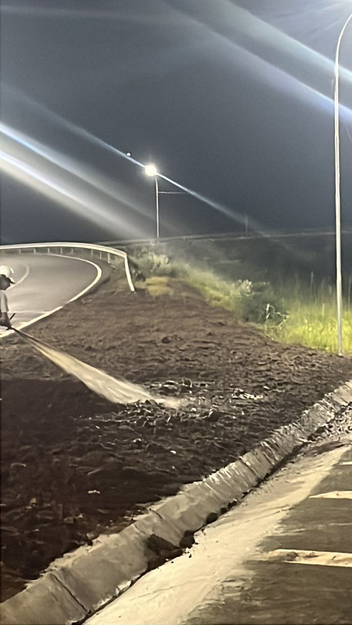 Aplicação noturna de hidrossemeadura em margem de rodovia