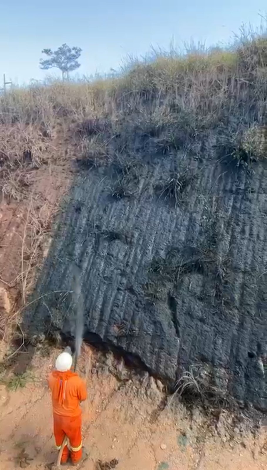 Operador aplicando hidrossemeadura em talude